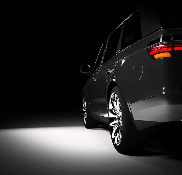 Vue de trois-quarts arrière d'un SUV de luxe noir brillant dans l'obscurité avec éclairage focalisé à Poissy dans les Yvelines 78