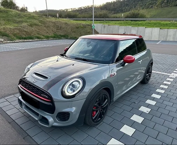 Mini Cooper John Cooper Works grise avec toit rouge garée sur un parking pavé à Poissy dans les Yvelines 78