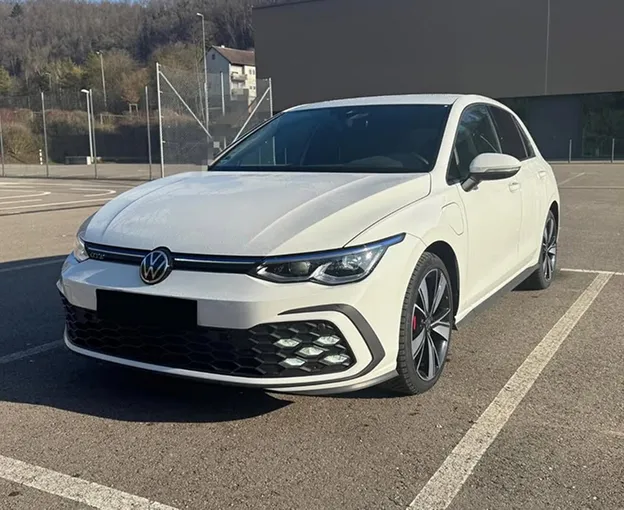 Volkswagen Golf GTE blanche garée sur un parking extérieur par une journée ensoleillée à Poissy dans les Yvelines 78