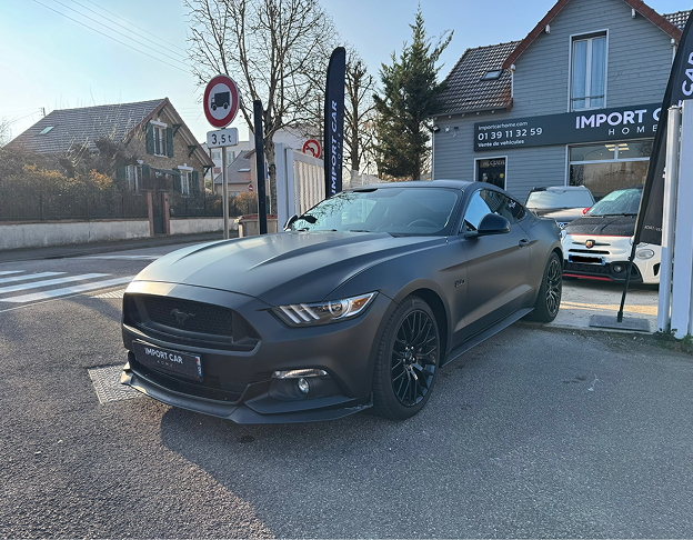 Ford Mustang noir mat garée devant une concession automobile Import Car Home à Poissy dans les Yvelines 78