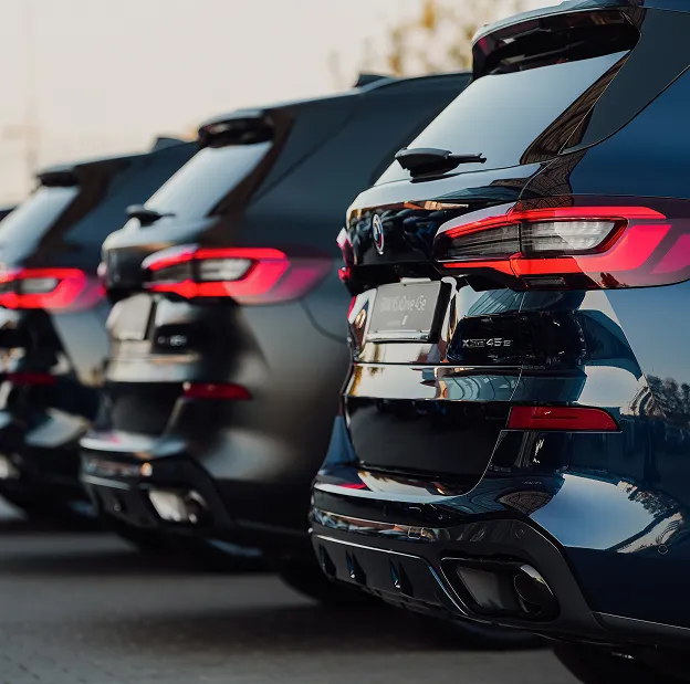 Alignement de SUV BMW X5 bleus et noirs vus de l'arrière avec feux allumés à Poissy dans les Yvelines 78
